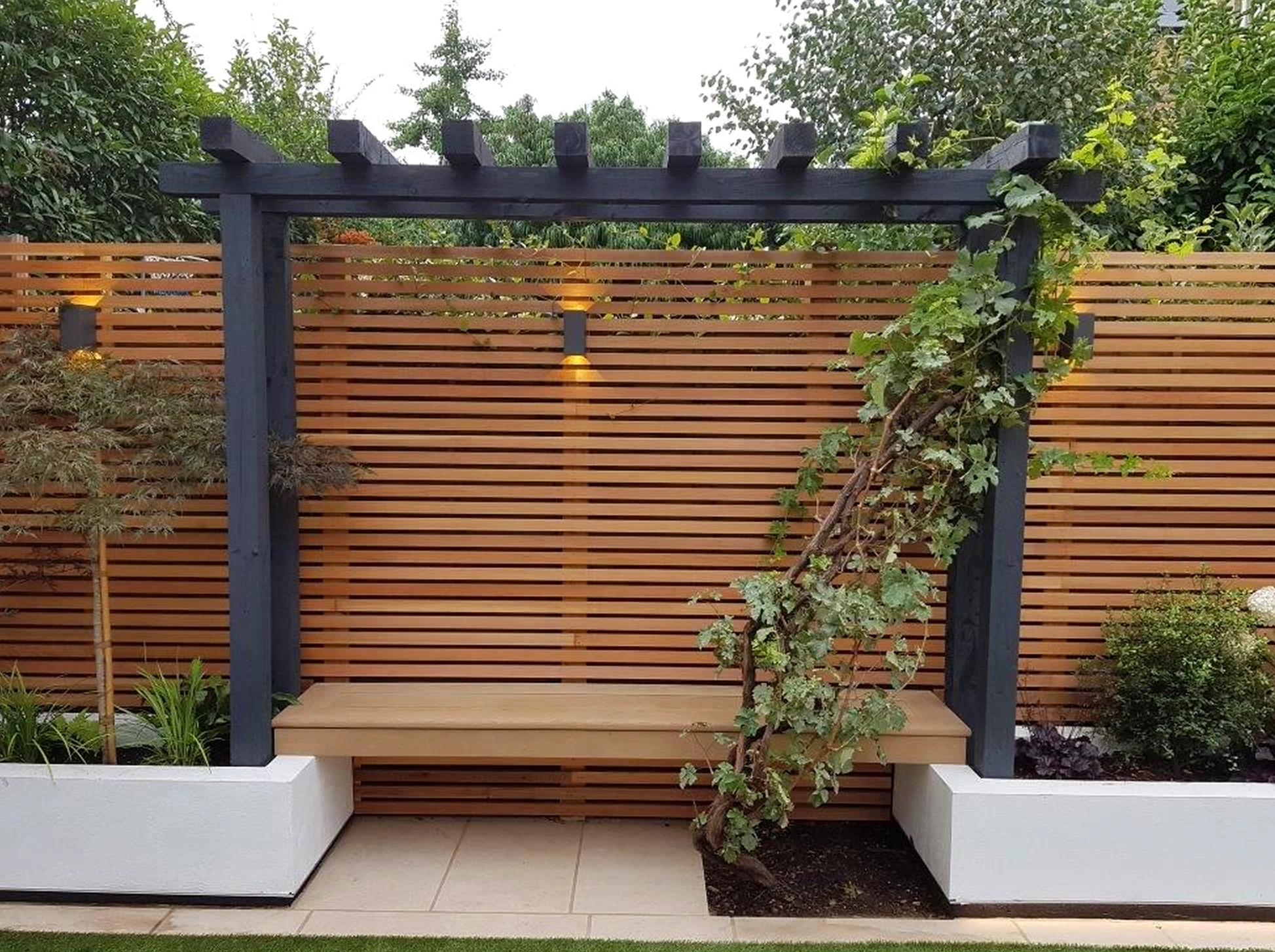 Textured fireplace area brings contrast to the garden edge, creating a mood that feels comfortable in daily use.