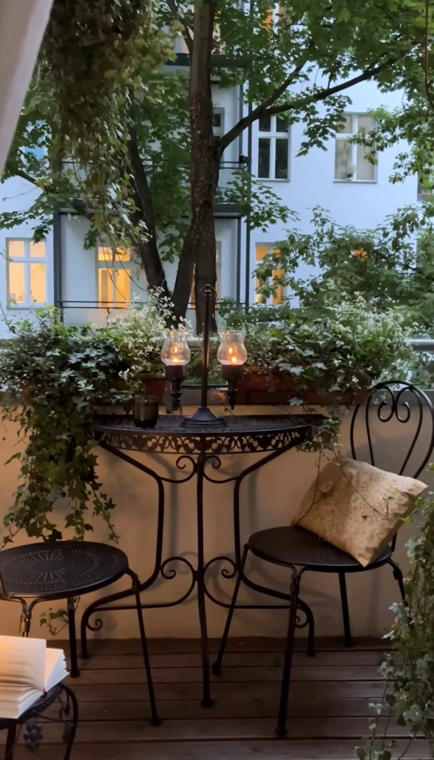 Leafy terrace table anchors the entry with depth, giving the view a mood that feels open and lived-in.